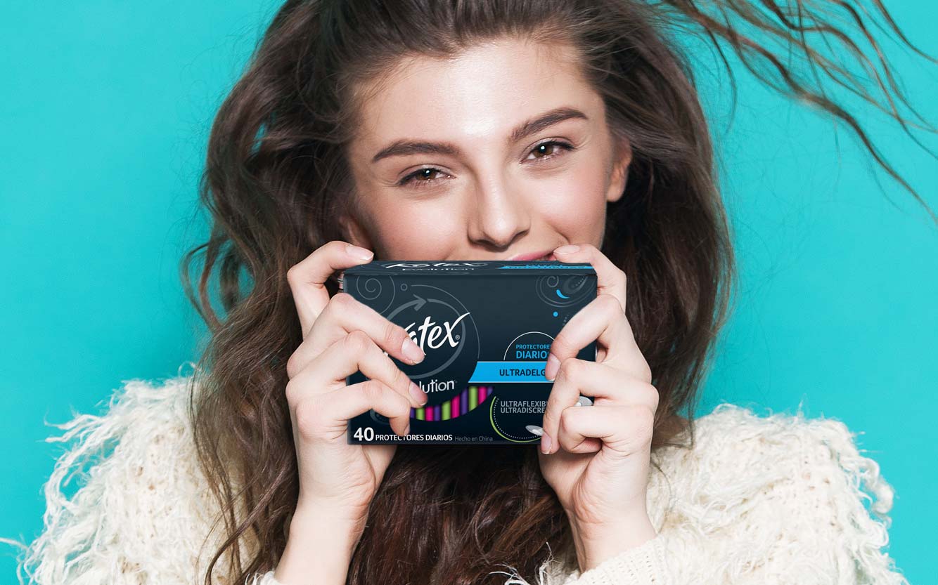 Young woman holding the new packaging and branding design for the new Kotex Evolution product line. Latin America.